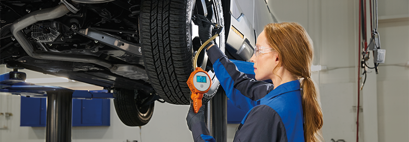 A Subaru technician checking tire pressure. | Frederick Subaru in Frederick MD
