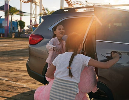 Two young girls getting into a Subaru Ascent